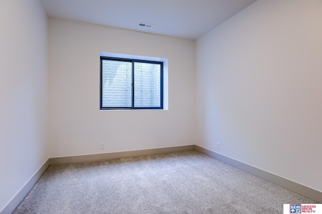 unfurnished room featuring baseboards, visible vents, and carpet