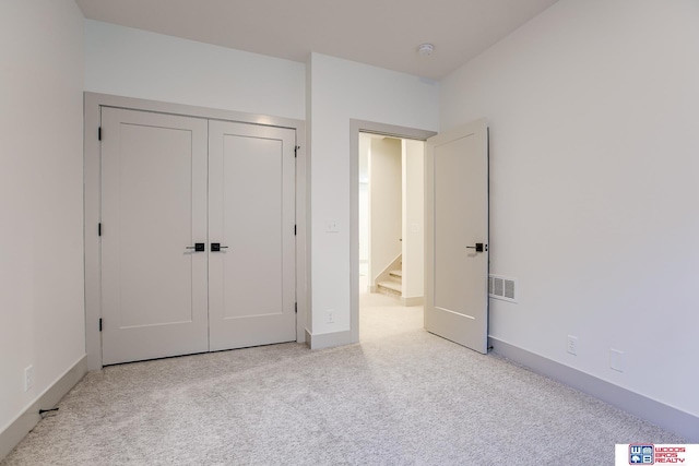 unfurnished bedroom featuring a closet, carpet, visible vents, and baseboards