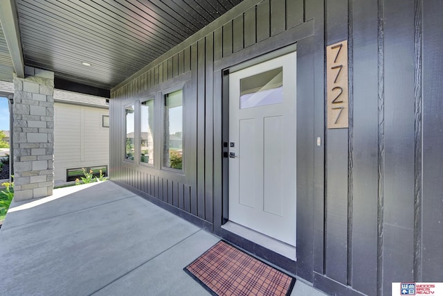 property entrance featuring board and batten siding and covered porch