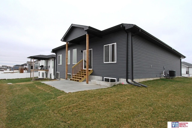 view of front of house featuring a front yard, entry steps, central AC, and a patio