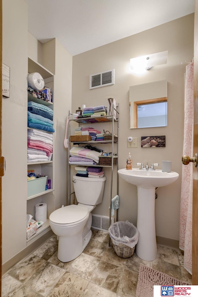 4821-31-41 Colfax Ave, Lincoln, NE 68504 - bathroom featuring toilet, baseboards, visible vents, and a sink