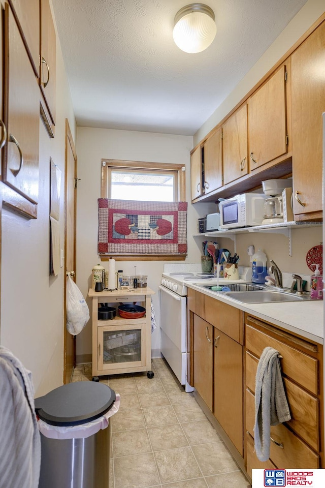 4821-31-41 Colfax Ave, Lincoln, NE 68504 - kitchen featuring a sink, white appliances, light countertops, and light tile patterned floors