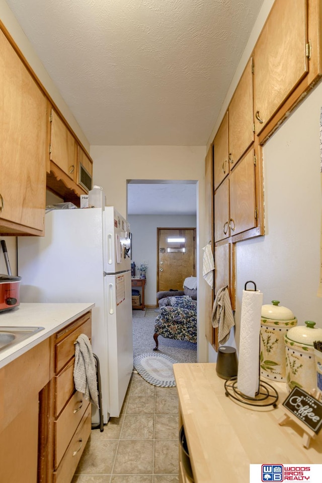 4821-31-41 Colfax Ave, Lincoln, NE 68504 - kitchen with freestanding refrigerator, light countertops, light tile patterned flooring, and a sink