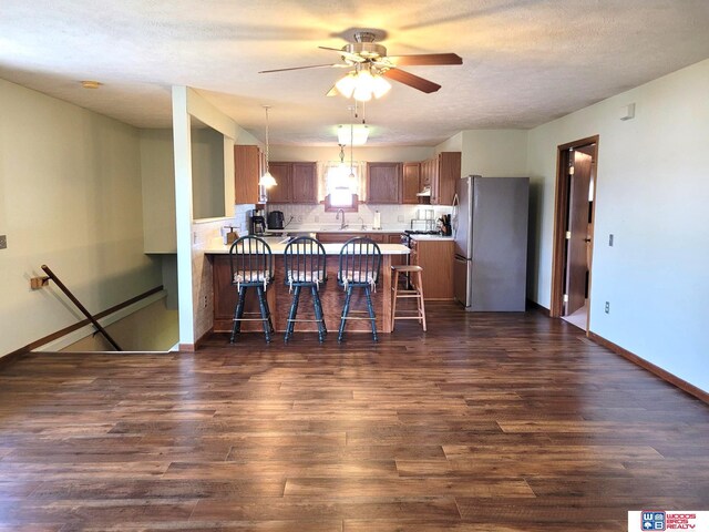 1321 Frances St, Goehner, NE 68364 - kitchen featuring a kitchen breakfast bar, ceiling fan, a peninsula, dark wood-type flooring, and freestanding refrigerator
