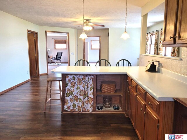 1321 Frances St, Goehner, NE 68364 - kitchen with a breakfast bar, brown cabinetry, a peninsula, hanging light fixtures, and ceiling fan