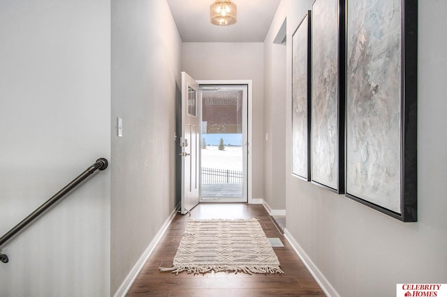 doorway with baseboards and wood finished floors