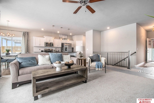 living area with recessed lighting, light carpet, and ceiling fan with notable chandelier