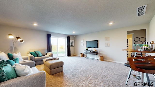 carpeted living area with a textured ceiling, baseboards, visible vents, and recessed lighting