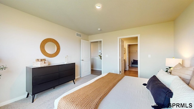bedroom featuring light colored carpet, baseboards, and visible vents