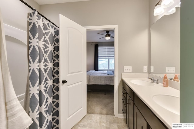 ensuite bathroom featuring double vanity, ensuite bath, ceiling fan, and a sink