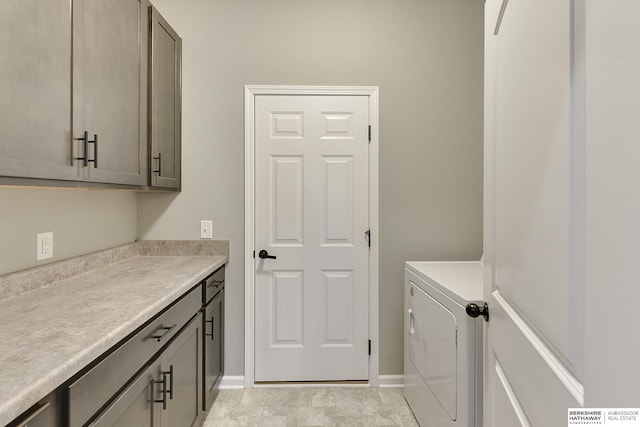 laundry area featuring cabinet space, washing machine and clothes dryer, and baseboards