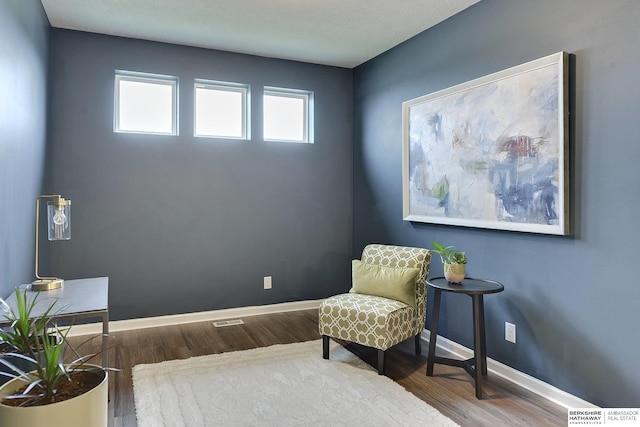 sitting room featuring baseboards and wood finished floors