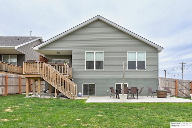 back of property featuring stairway, fence, a yard, and a patio