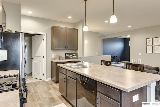kitchen with a sink, range with gas cooktop, visible vents, freestanding refrigerator, and dishwasher