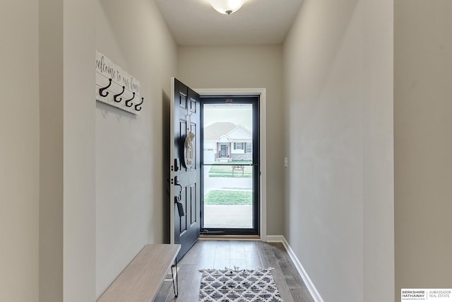 doorway with baseboards and light wood-style floors
