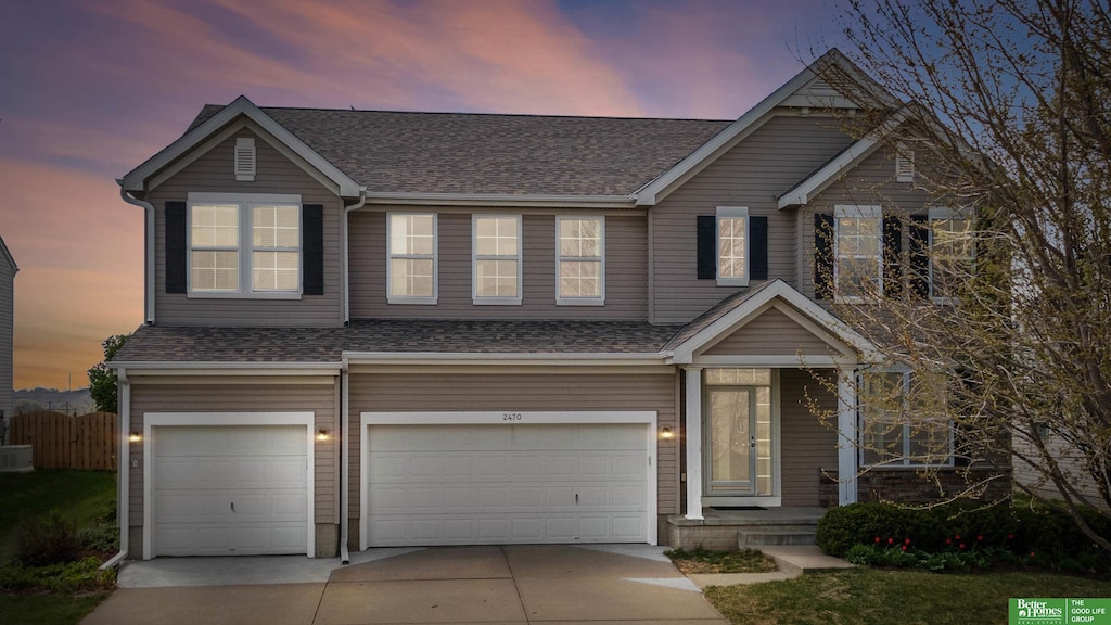 view of front of property featuring an attached garage, driveway, and roof with shingles