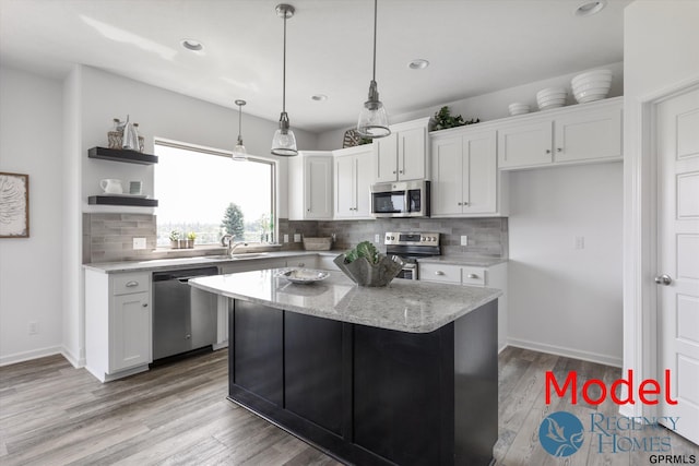 kitchen with white cabinets, stainless steel appliances, decorative backsplash, pendant lighting, and a kitchen island