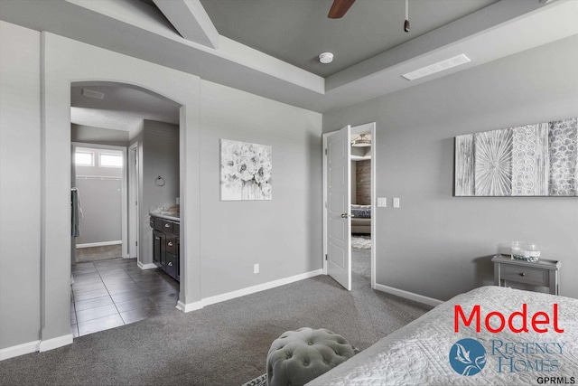 bedroom featuring connected bathroom, arched walkways, baseboards, dark colored carpet, and visible vents