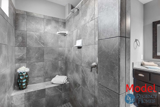 full bathroom featuring vanity and a tile shower