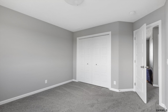 unfurnished bedroom with baseboards, a closet, and carpet