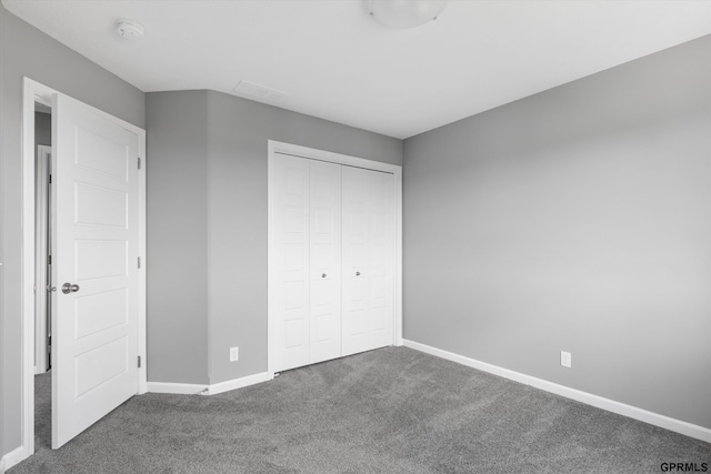 unfurnished bedroom with baseboards, a closet, and carpet