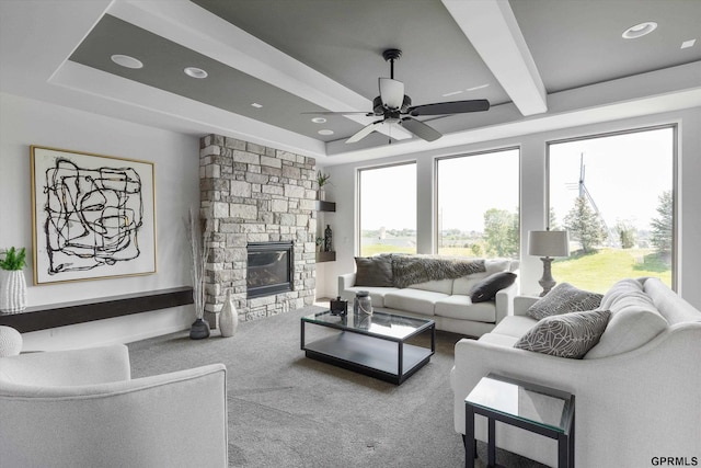 carpeted living room featuring recessed lighting, a stone fireplace, beam ceiling, and a ceiling fan