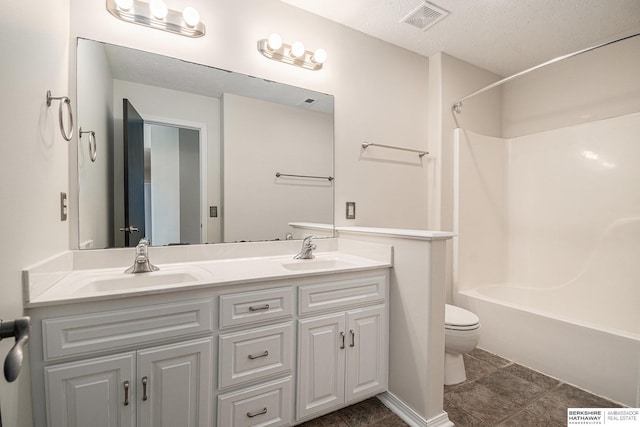 full bath featuring visible vents, a sink, double vanity, and toilet