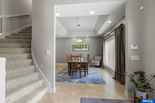 dining space with stairs, light tile patterned floors, a tray ceiling, baseboards, and recessed lighting