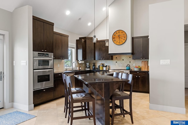 kitchen with stainless steel double oven, dark brown cabinets, a sink, baseboards, and high vaulted ceiling