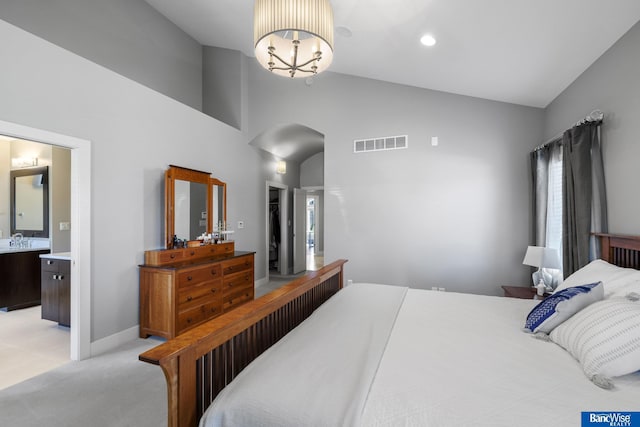 bedroom featuring an inviting chandelier, visible vents, light carpet, arched walkways, and high vaulted ceiling