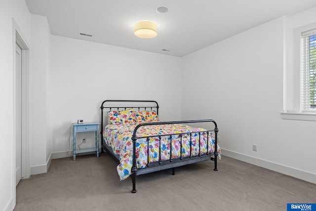 carpeted bedroom with baseboards and visible vents