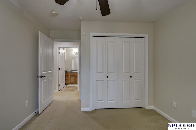 unfurnished bedroom featuring light carpet, a closet, and baseboards