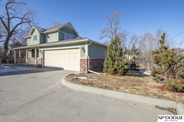 view of side of property with concrete driveway, brick siding, and a garage