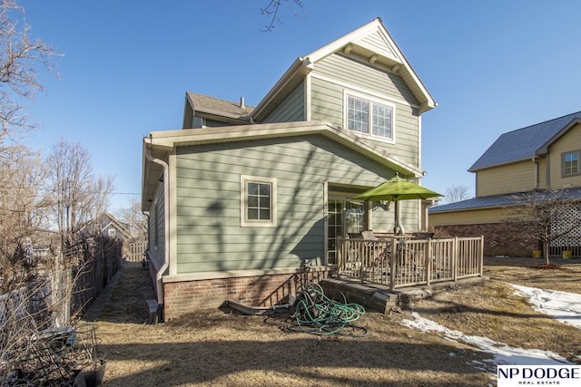 back of property with fence and a deck