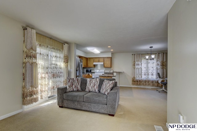 living area with visible vents, baseboards, and light colored carpet