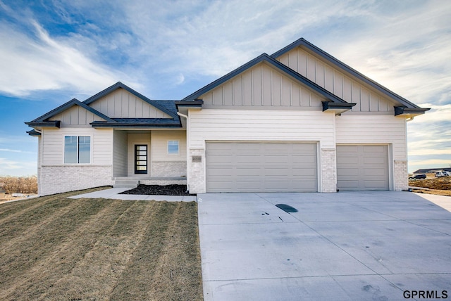 view of front of house with board and batten siding, brick siding, a garage, and concrete driveway