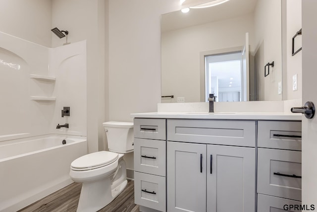 full bathroom featuring toilet, bathtub / shower combination, baseboards, wood finished floors, and vanity