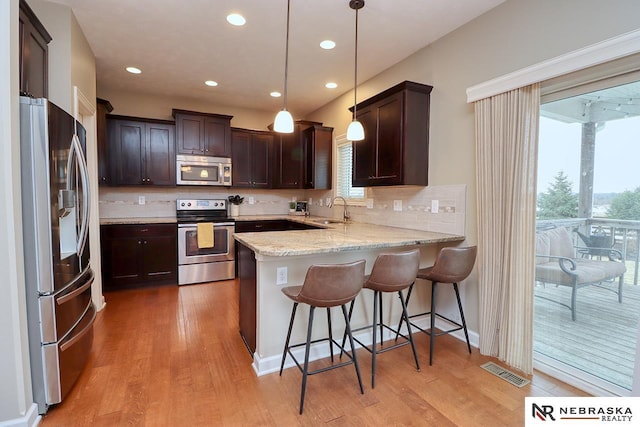 9441 Southern Sky Cir, Lincoln, NE 68505 - kitchen featuring a peninsula, dark brown cabinets, stainless steel appliances, and a sink