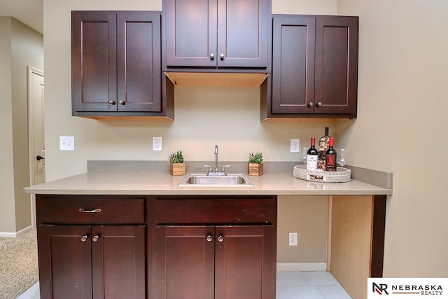 9441 Southern Sky Cir, Lincoln, NE 68505 - kitchen featuring baseboards, dark brown cabinetry, a sink, and light countertops