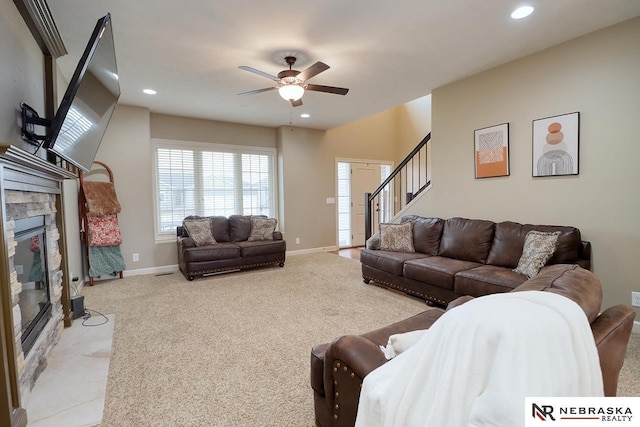 9441 Southern Sky Cir, Lincoln, NE 68505 - carpeted living room with baseboards, recessed lighting, ceiling fan, stairway, and a stone fireplace