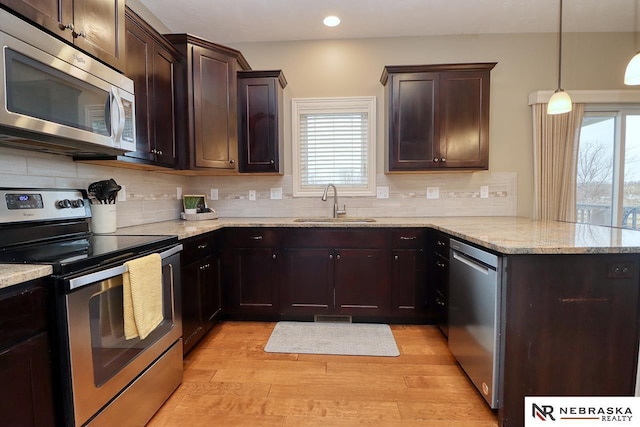 9441 Southern Sky Cir, Lincoln, NE 68505 - kitchen with a peninsula, appliances with stainless steel finishes, a sink, and plenty of natural light