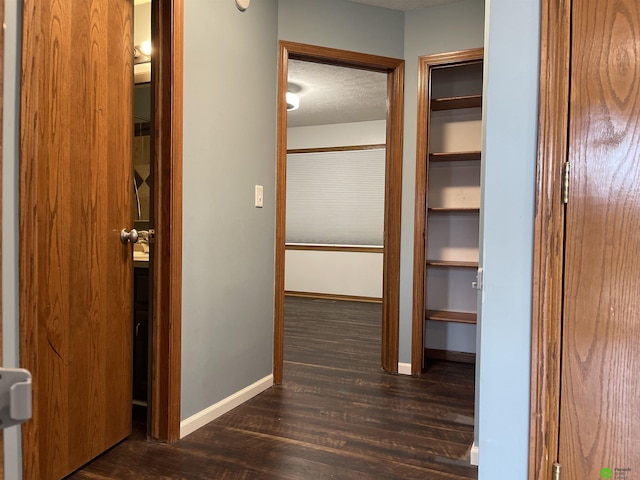 corridor with dark wood-style floors and baseboards