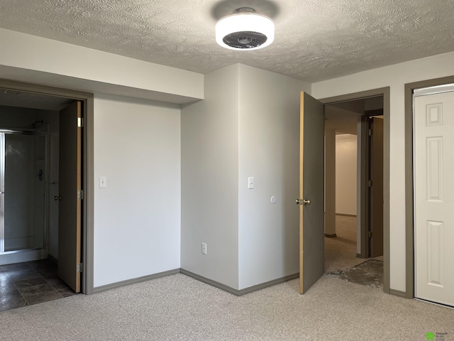 below grade area with baseboards, a textured ceiling, and carpet flooring
