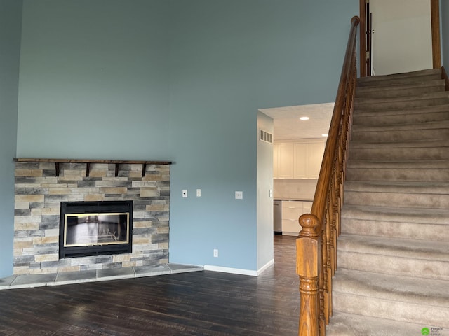 stairway with recessed lighting, a fireplace, visible vents, baseboards, and wood finished floors