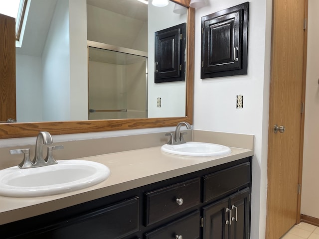bathroom with double vanity, a stall shower, and a sink