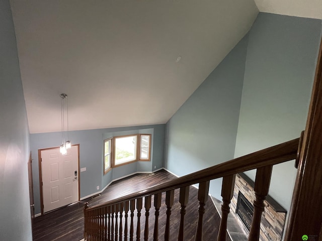 staircase featuring lofted ceiling, wood finished floors, and baseboards