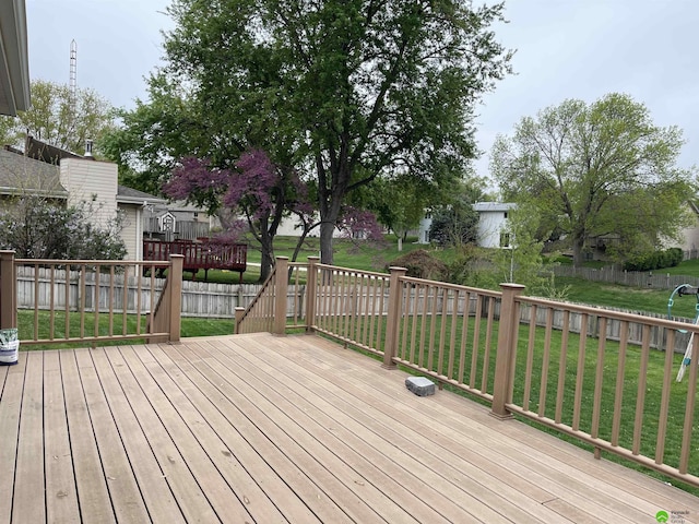 wooden deck featuring fence and a yard