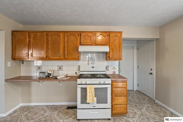 2725 Monroe St, Omaha, NE 68107 - kitchen featuring brown cabinetry, backsplash, white gas stove, and under cabinet range hood