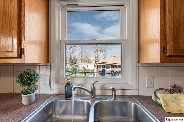 2725 Monroe St, Omaha, NE 68107 - kitchen with decorative backsplash, a sink, and brown cabinets