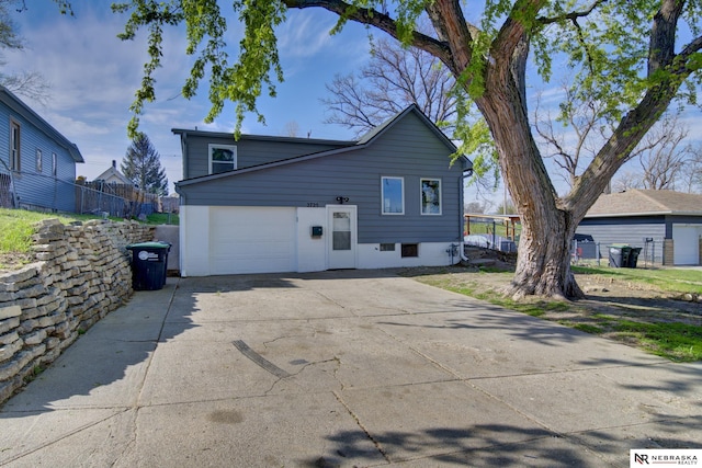 2725 Monroe St, Omaha, NE 68107 - view of side of home with a garage, concrete driveway, and fence